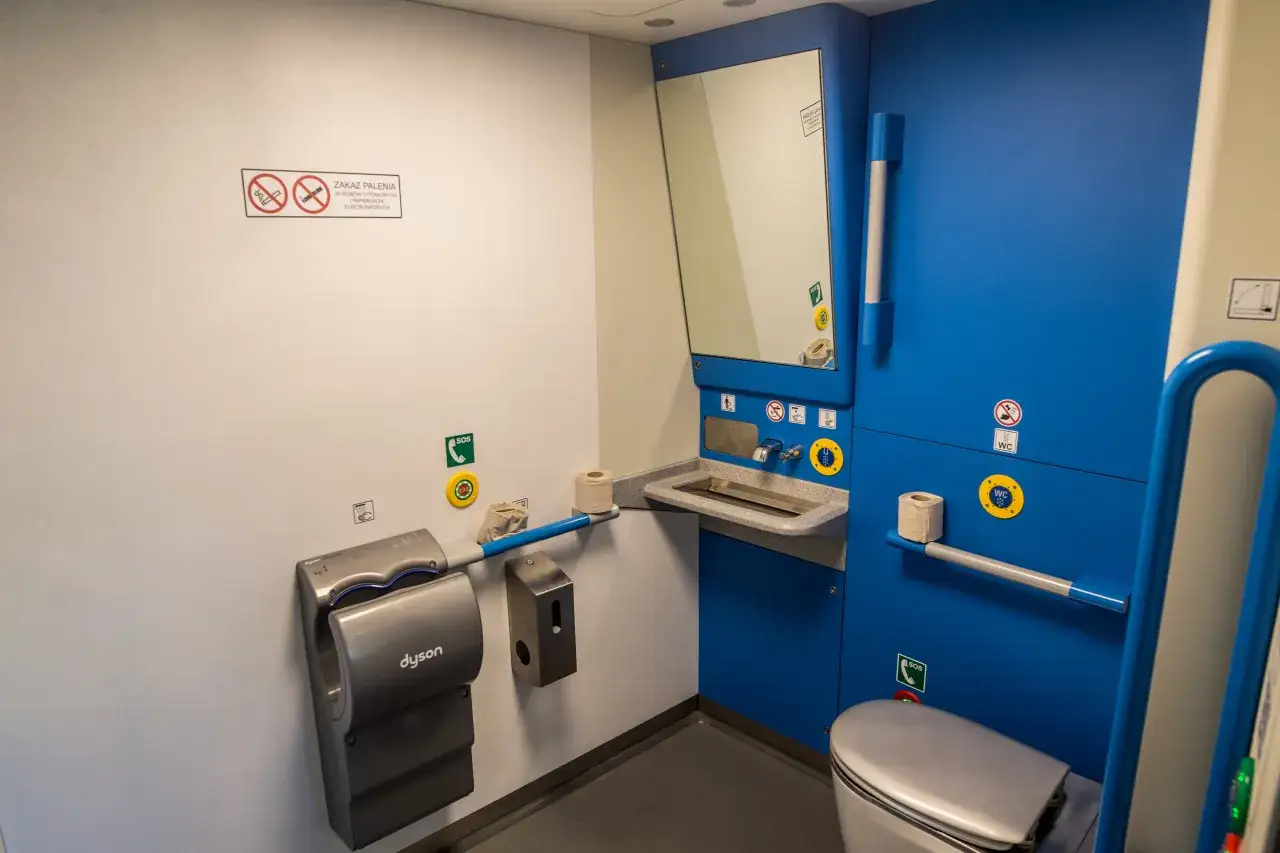 W toalecie w Kolejach Śląskich znajdziesz umywalkę, suszarkę Dyson i toaletę.