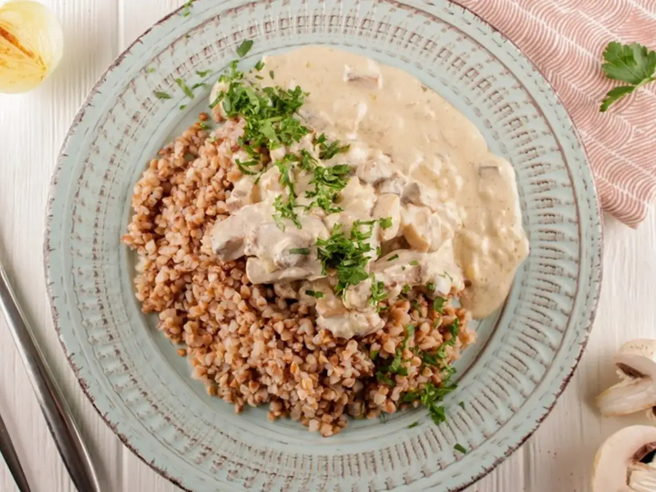 Kasza gryczana z kurczakiem w kremowym sosie pieczarkowym, posypana natką pietruszki. Pyszne danie, co z sosem pieczarkowym?