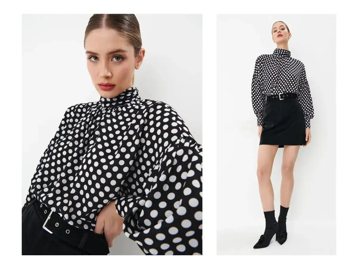 Modelka w bluzce w grochy i czarnej spódniczce, prezentująca styl retro ubrania.