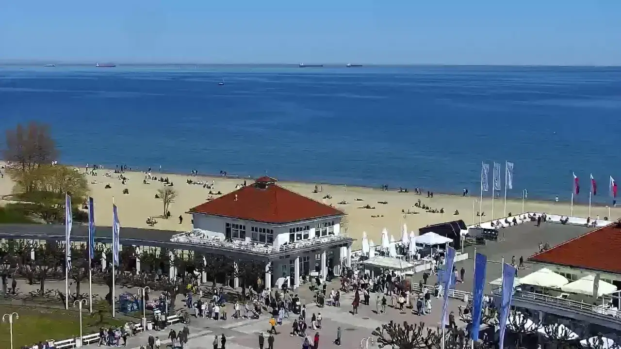 Sopot: plaża, morze, budynek z czerwoną dachem, ludzie spacerujący. Idealne miejsce, by zobaczyć w Sopocie, co oferuje wybrzeże.