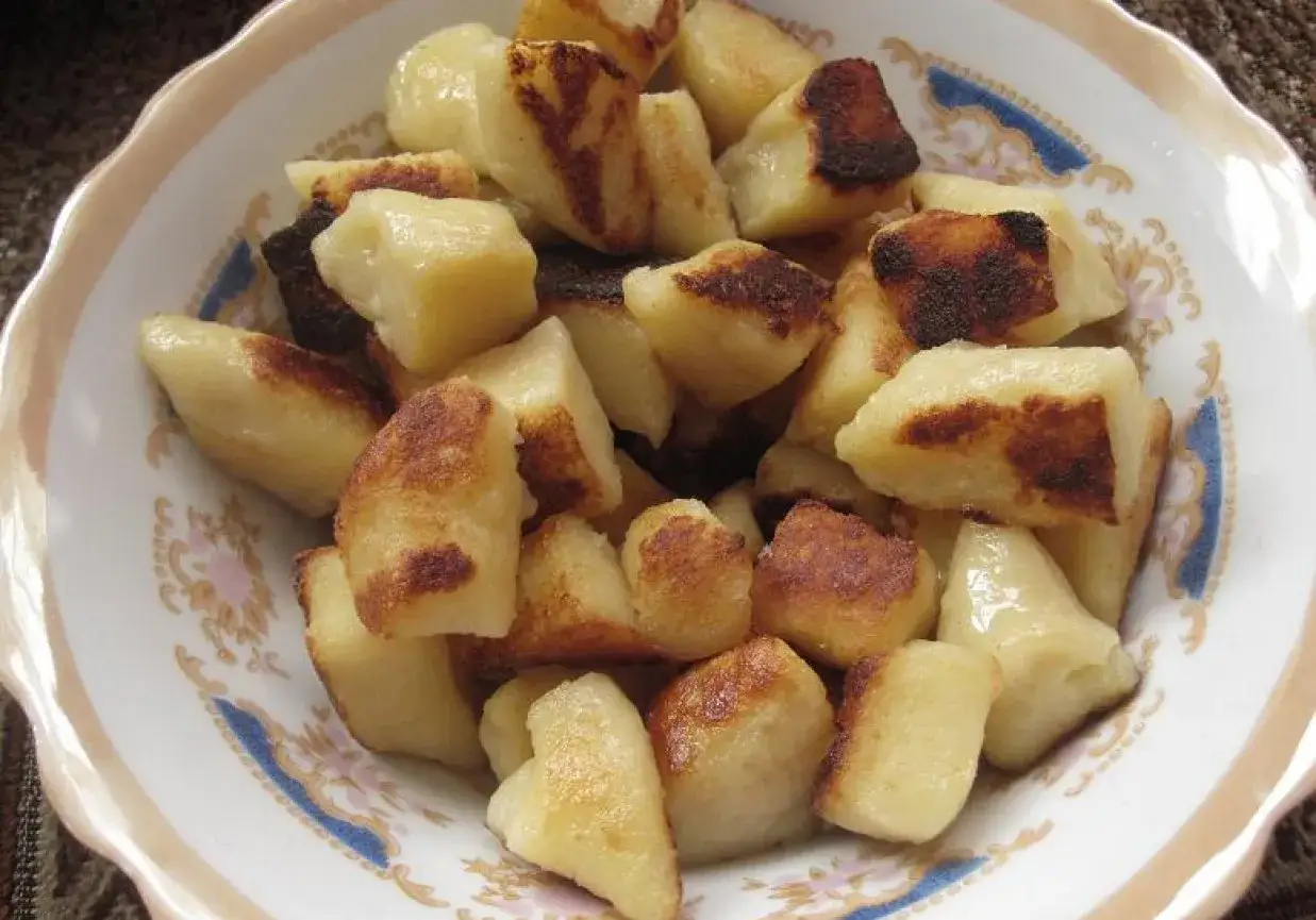 Usmażone kopytka z ugotowanych ziemniak&oacute;w, lekko zrumienione, podane w miseczce. Pyszny pomysł, co zrobić z ugotowanych ziemniak&oacute;w.