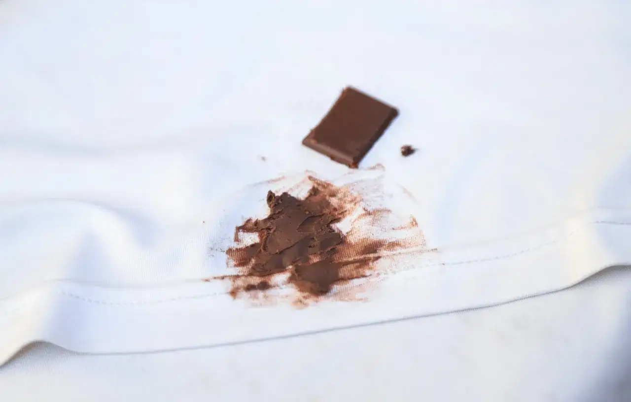 plama z czekolady na białej koszuli z bliska