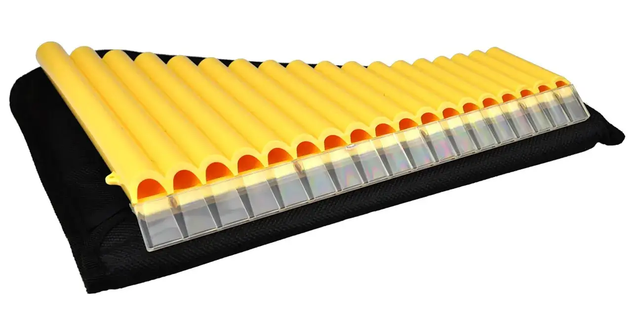 Żółta fletnia Pana instrument muzyczny, złożona z wielu rurek, leży na czarnym etui.