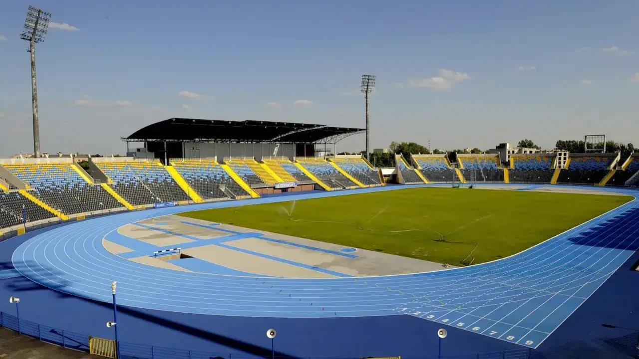 Stadion lekkoatletyczny z niebieską bieżnią i zieloną murawą, gotowy na Memoriał Ireny Szewińskiej.