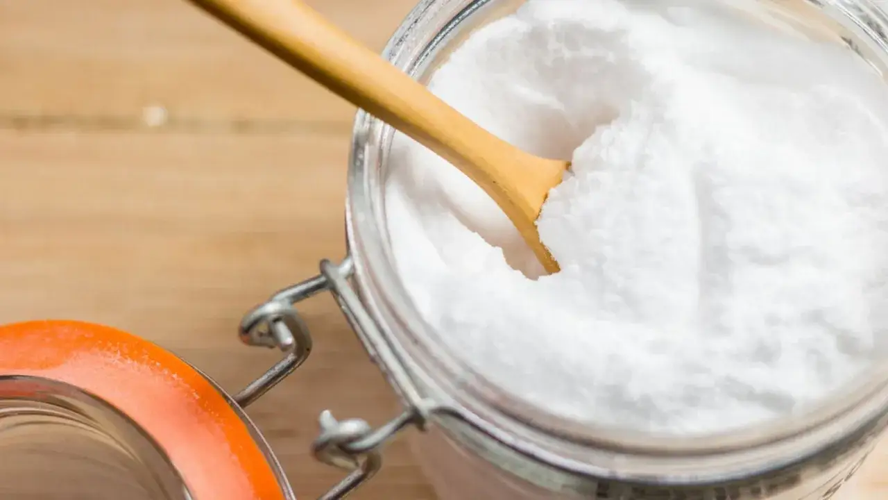 Słoik z sodą oczyszczoną i drewnianą łyżeczką. Czy soda oczyszczona jest zdrowa? Dowiedz się więcej o jej zastosowaniach.