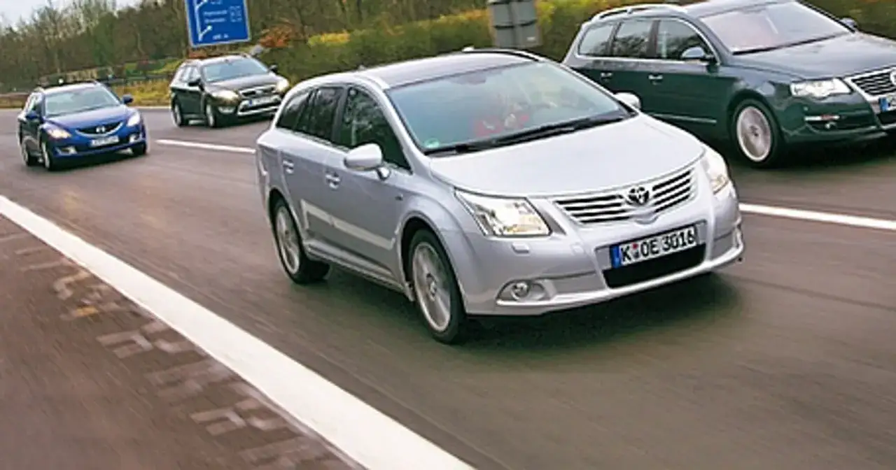 Srebrna Toyota Avensis kombi na autostradzie, obok inne samochody. Dane techniczne tego modelu są imponujące.