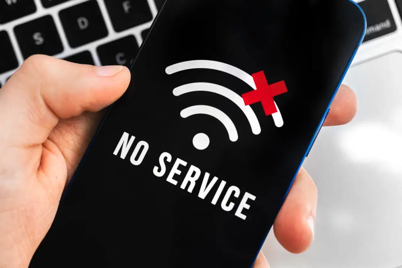 Telefon pokazuje brak zasięgu, symbol Wi-Fi z przekreśleniem i napis 