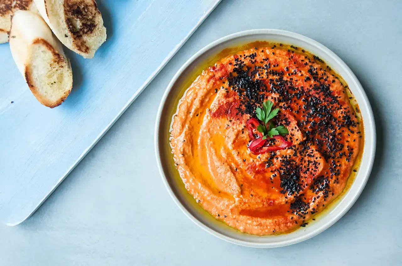domowy hummus w misce z oliwą i papryką