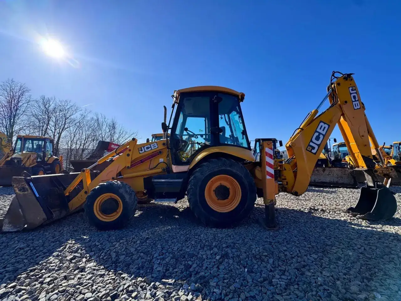 Żółta koparko-ładowarka JCB na placu budowy. Zastanawiasz się, jaką koparko ładowarkę kupić? Ta maszyna to dobry wybór.