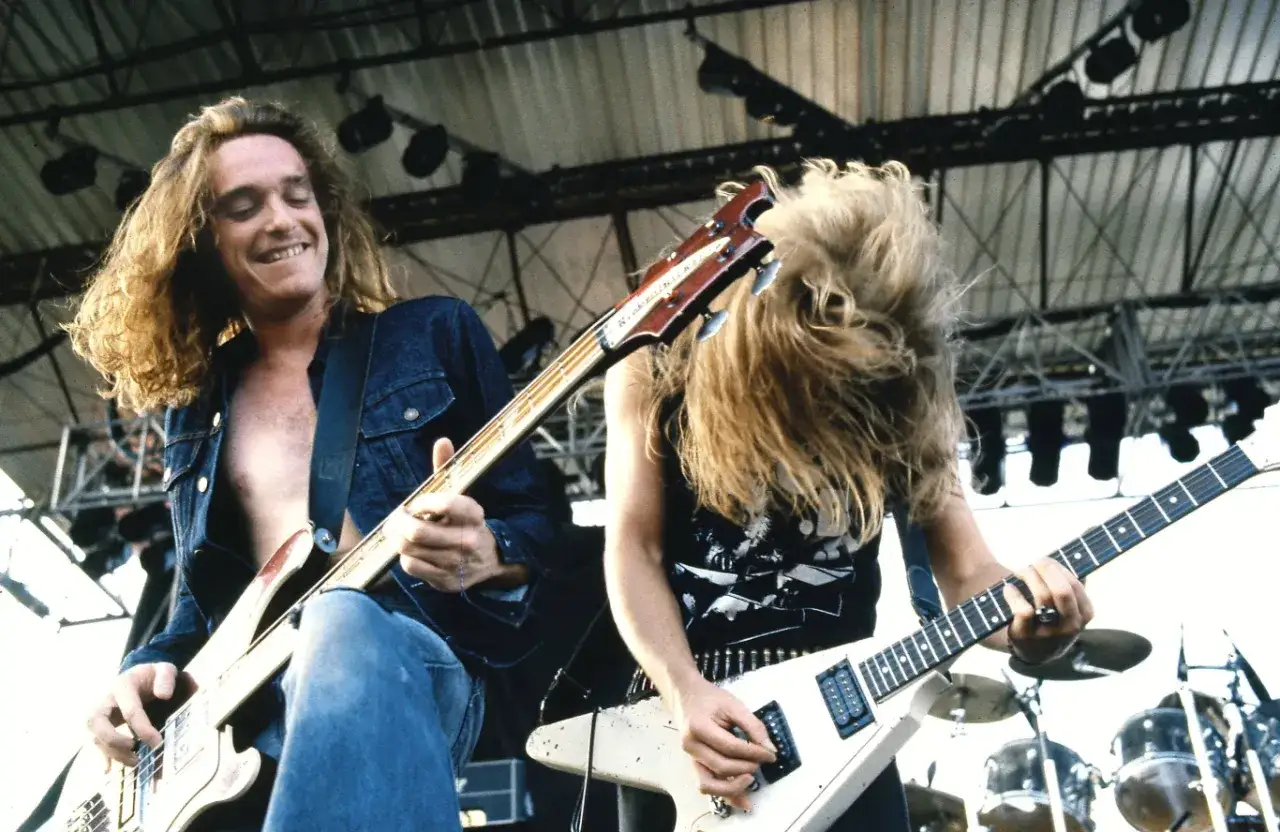 Cliff Burton, basista Metalliki, grający na scenie. Tragiczne okoliczności jego śmierci wciąż poruszają fan&oacute;w.