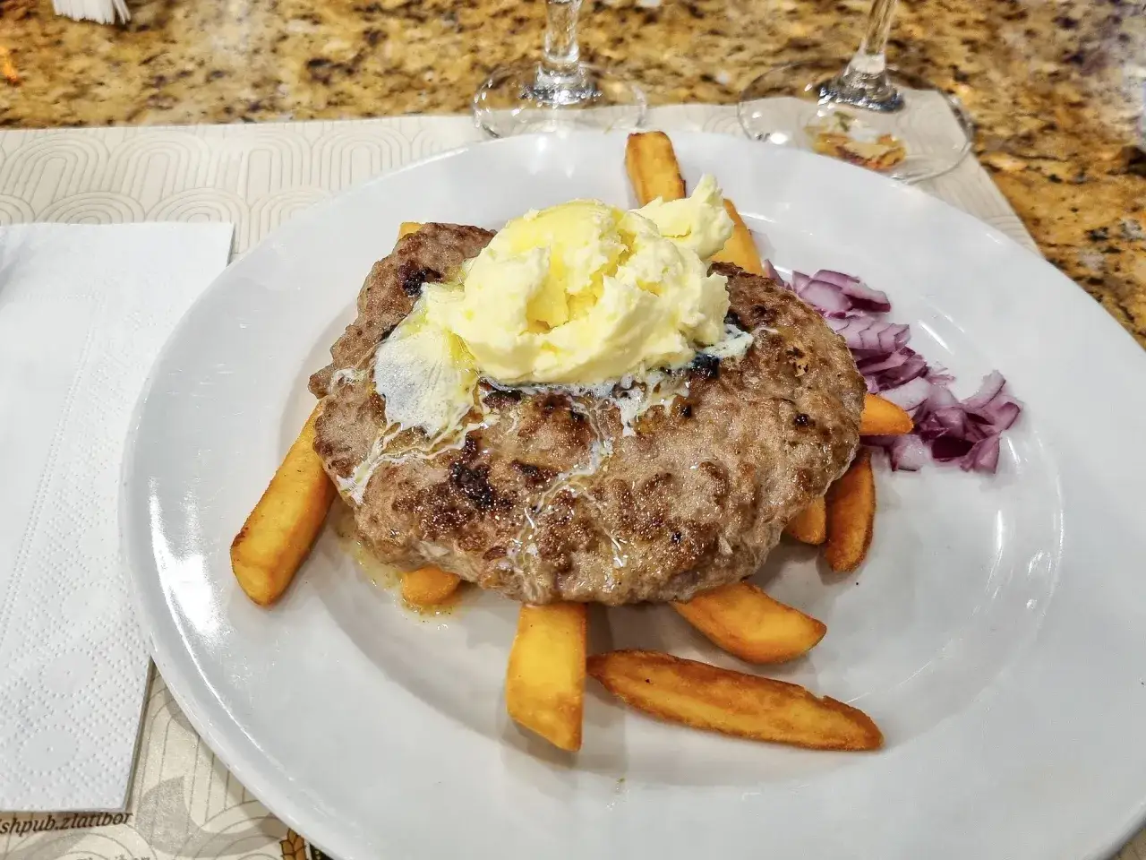 Placki z mięsa mielonego z g&oacute;rą kremowego masła, frytkami i czerwoną cebulą. Prawdziwy smak bałkański!