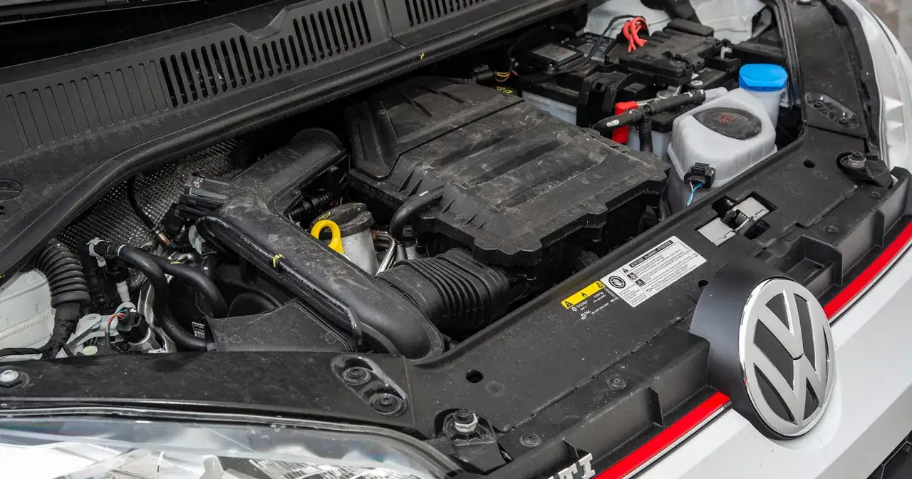 Silnik 1.0 MPI pod maską Volkswagena. Widoczny akumulator, przewody i elementy układu dolotowego.