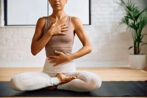 osoba wykonująca ćwiczenia oddechowe, spokojna twarz, relaks