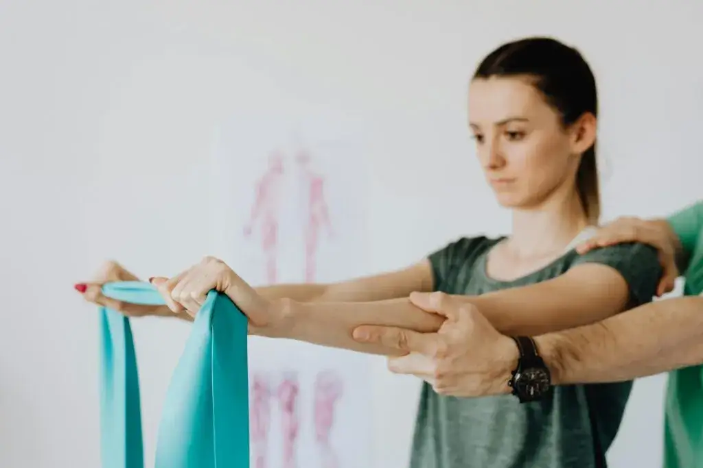 fizjoterapeuta wykonujący ćwiczenia z pacjentem z osteofitozą