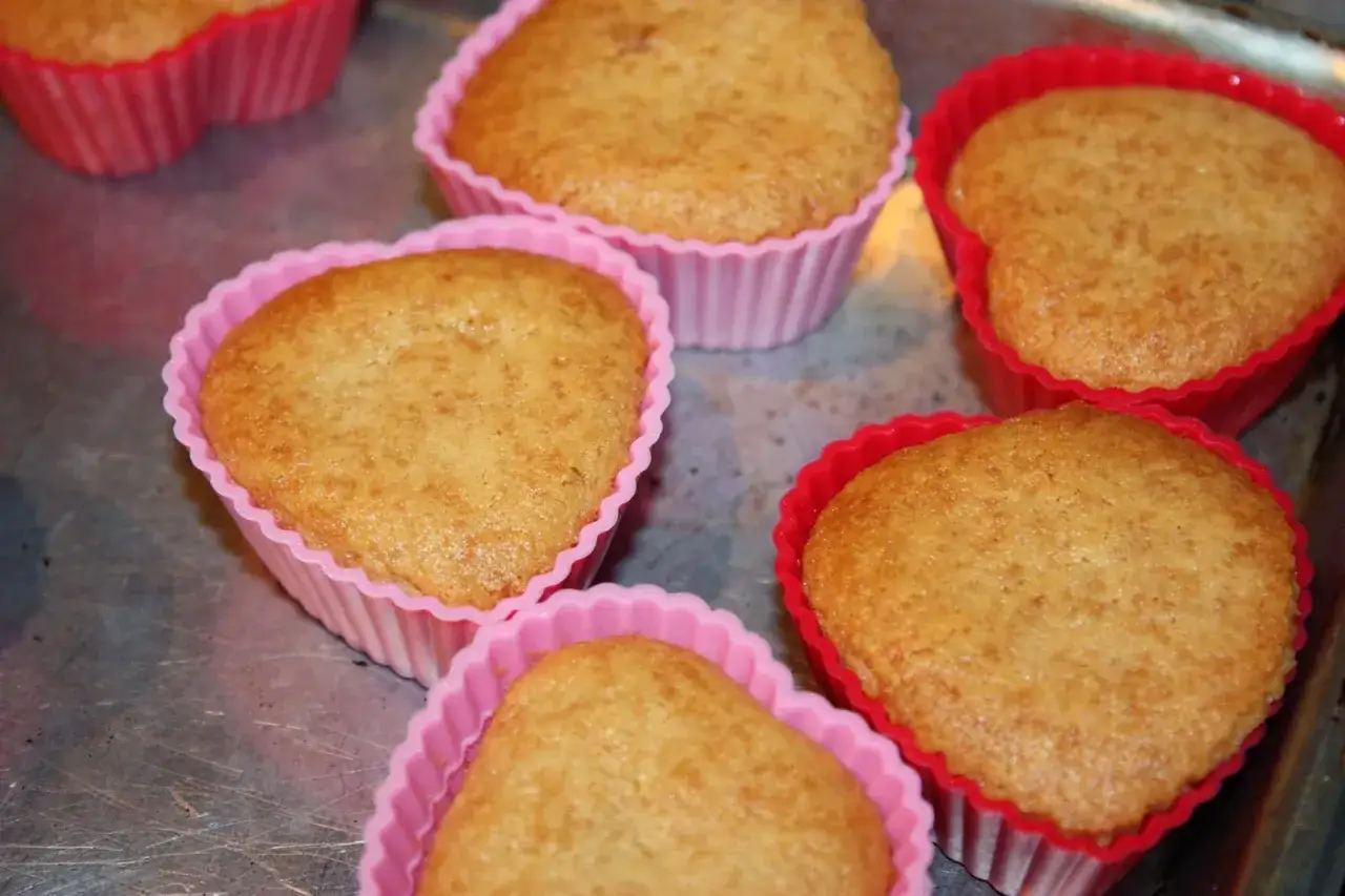 Słodkie babeczki bezglutenowe w r&oacute;żowych i czerwonych foremkach. Idealne na deser, zgodnie z przepisem.