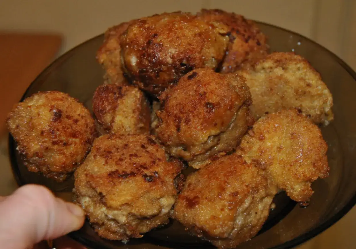 Złociste, chrupiące pieczarki nadziewane mięsem mielonym, ułożone na ciemnym talerzu. Pyszna przekąska gotowa do podania.