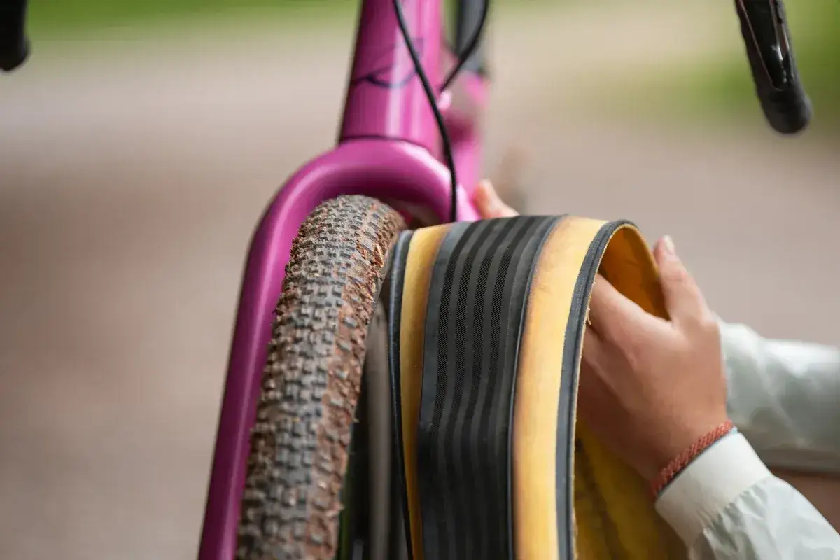 Rowerzysta przygotowuje nowe tpi opony do roweru gravelowego.