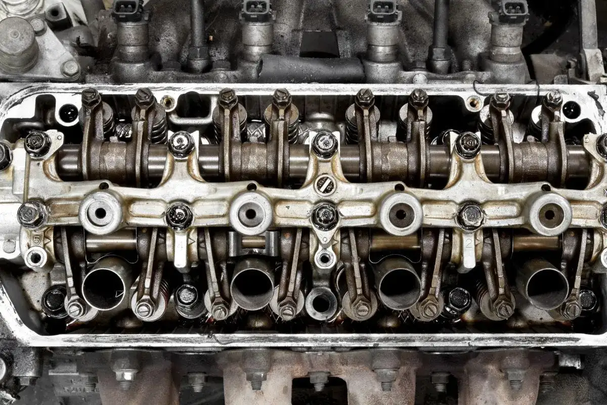 Silnik w trakcie wymiany uszczelki pokrywy zaworów. Widoczne wałki rozrządu, popychacze i zawory.
