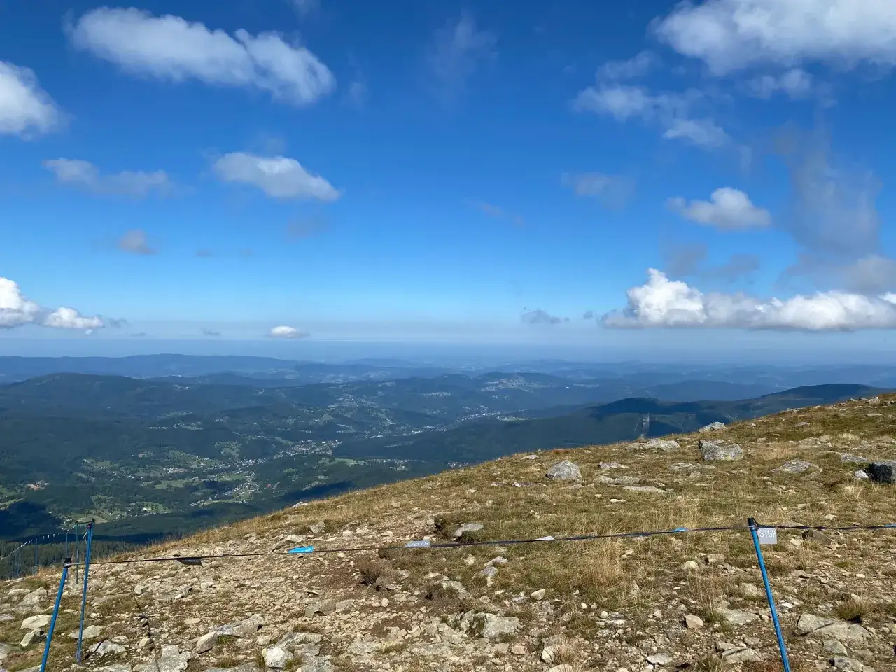 Widok z Babiej G&oacute;ry, pokazujący, jakie to g&oacute;ry: łagodne zbocza, lasy i doliny z zabudowaniami w oddali.