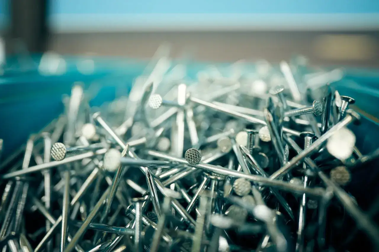 Stos gwoździ, idealnych do deskowania dachu. Wybór odpowiednich gwoździ to klucz do trwałej konstrukcji.