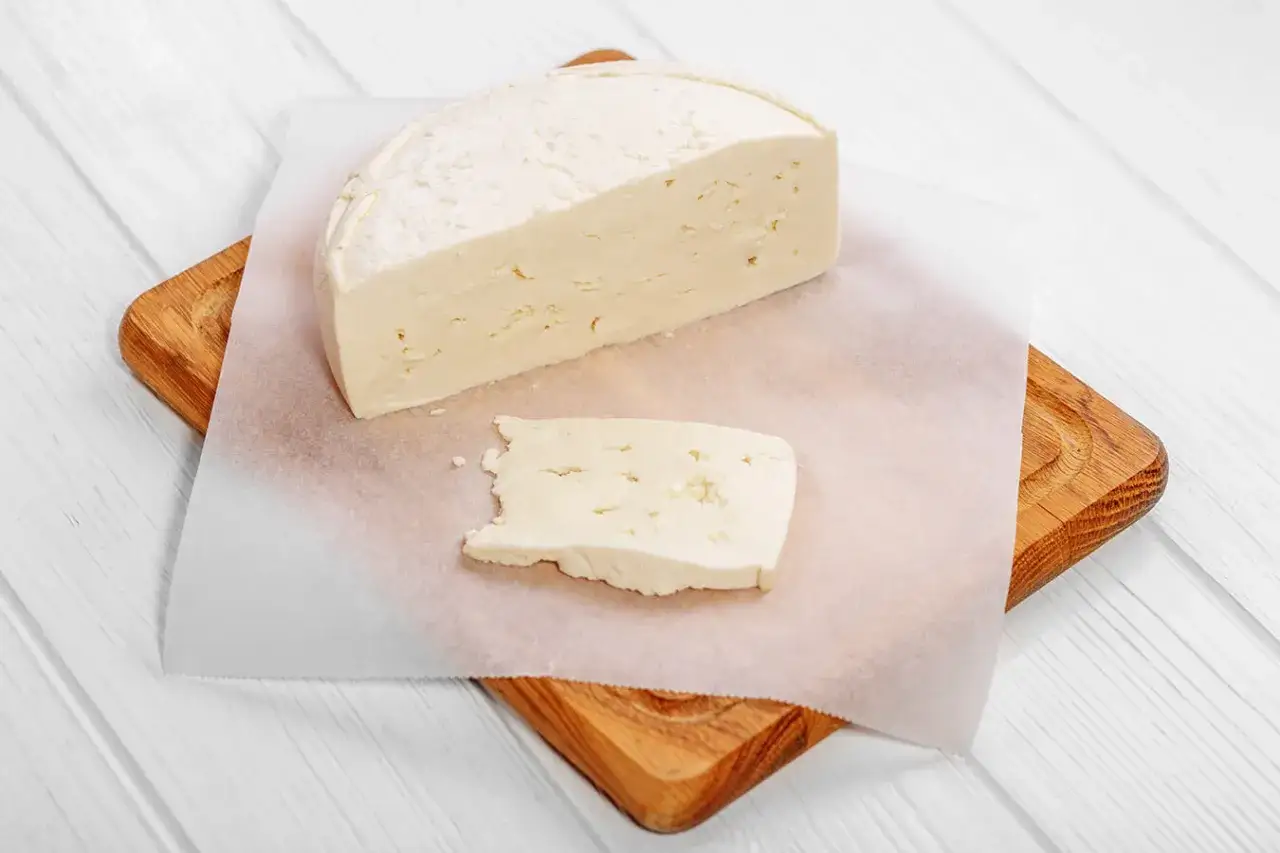 Biały ser na desce, zastanawiasz się, czy można mrozić biały ser? Ten świeży ser wygląda apetycznie.