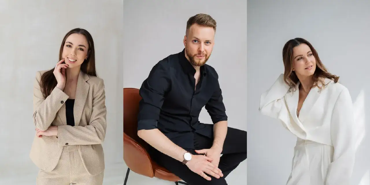 Trzy osoby w eleganckich strojach. Kobieta w beżowym garniturze, mężczyzna w czarnej koszuli i kobieta w białym komplecie. Dobry fotograf uchwycił ich profesjonalny wizerunek.