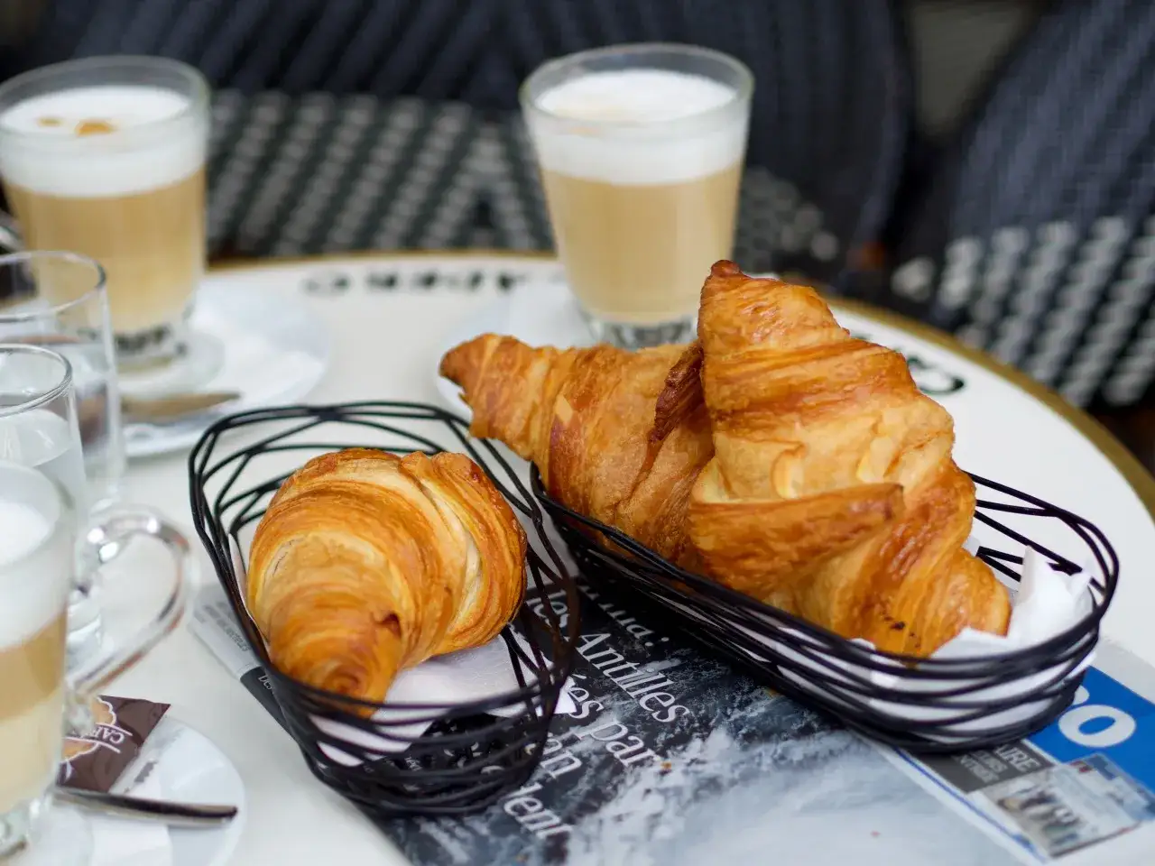 Pyszne rogaliki i kawa latte – to warto zjeść w Paryżu, delektując się porankiem w kawiarni.
