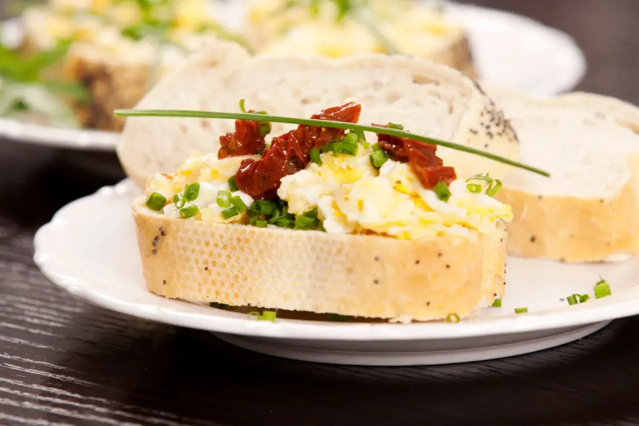 Pyszna pasta jajeczna na grzance z suszonymi pomidorami i szczypiorkiem. Idealna na śniadanie, gdy chcesz wiedzieć, jak zrobić pastę jajeczną.