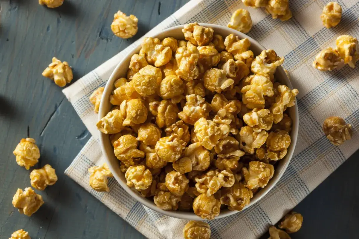 Miseczka pełna chrupiącego popcornu karmelowego, idealna do domowego seansu. Pyszna przekąska, jak zrobić popcorn karmelowy.