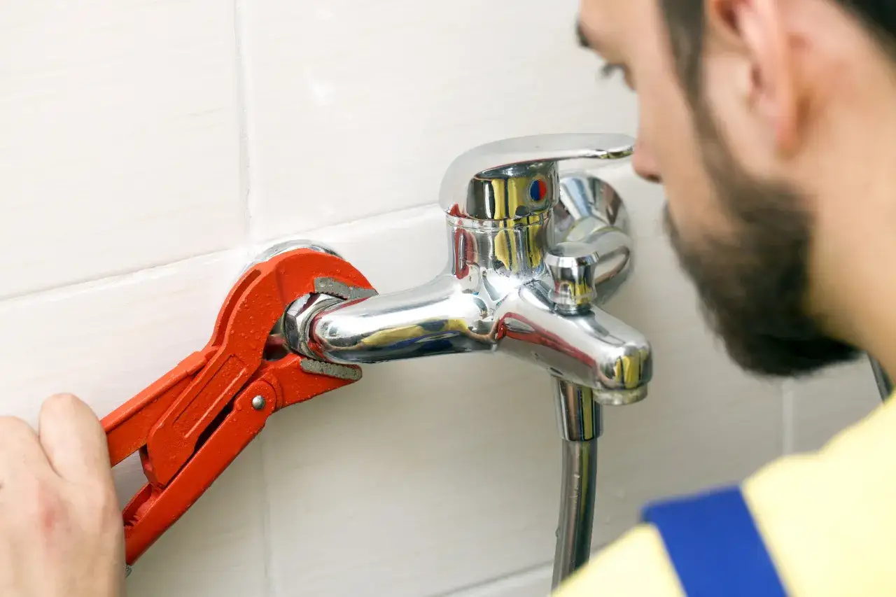 Hydraulik dokręca baterię wannową. Dowiedz się, ile kosztuje wymiana baterii wannowej i jakie są koszty naprawy.