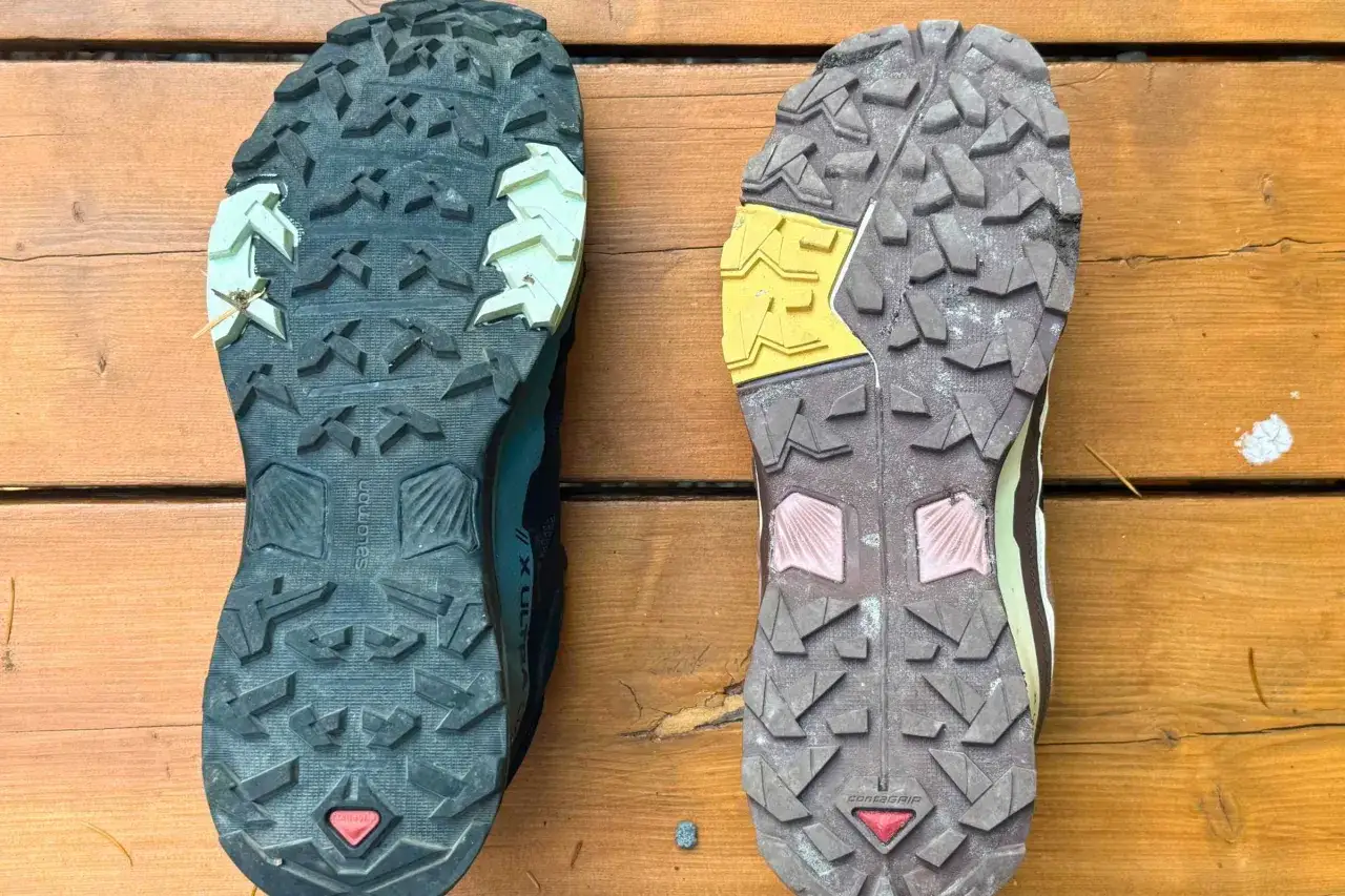 Podeszwy but&oacute;w Salomon z technologią Contagrip. Jedna jest nowa, czarna, druga używana, brązowa.