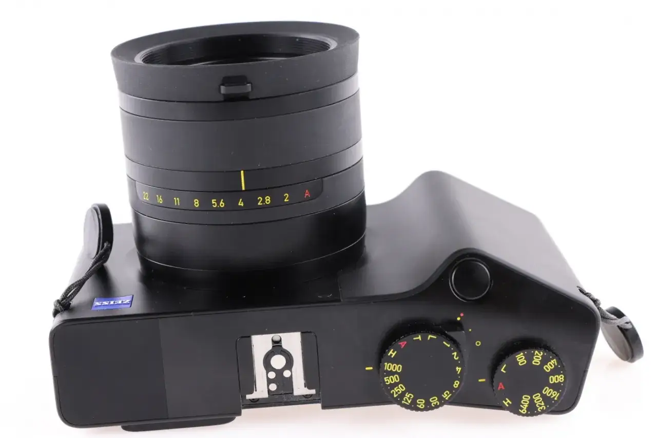 Czarny aparat Zeiss ZX1 z obiektywem i pokrętłami ustawień.