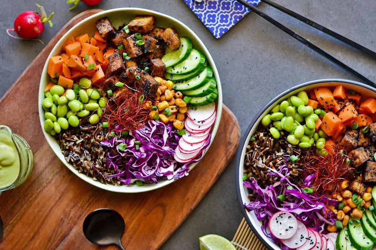 Kolorowe miski z ryżem, edamame, pieczonym tofu i warzywami. Idealne dla osób ceniących dietę bez mięsa.