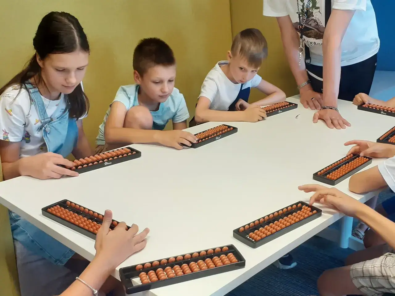 Dzieci ćwiczą arytmetykę mentalną na liczydłach. Czy warto? Tak, to świetna zabawa rozwijająca umysł!