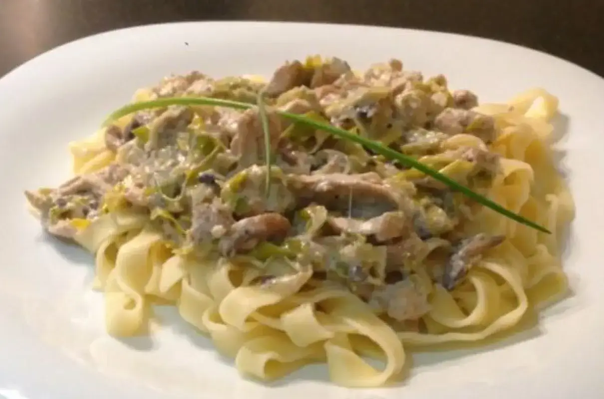 Tagliatelle z kremowym sosem grzybowym i porem, ozdobione szczypiorkiem. Pyszne danie, które sprawdzi się zamiast makaronu spaghetti.