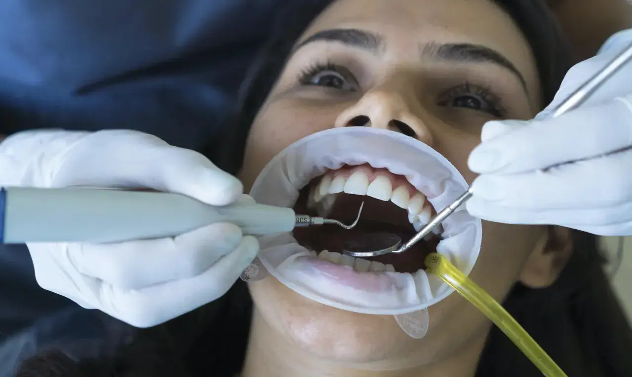Pacjentka u dentysty. Zastanawiasz się, ile kosztuje wizyta u dentysty prywatnie? Zobacz, jak wygląda zabieg.