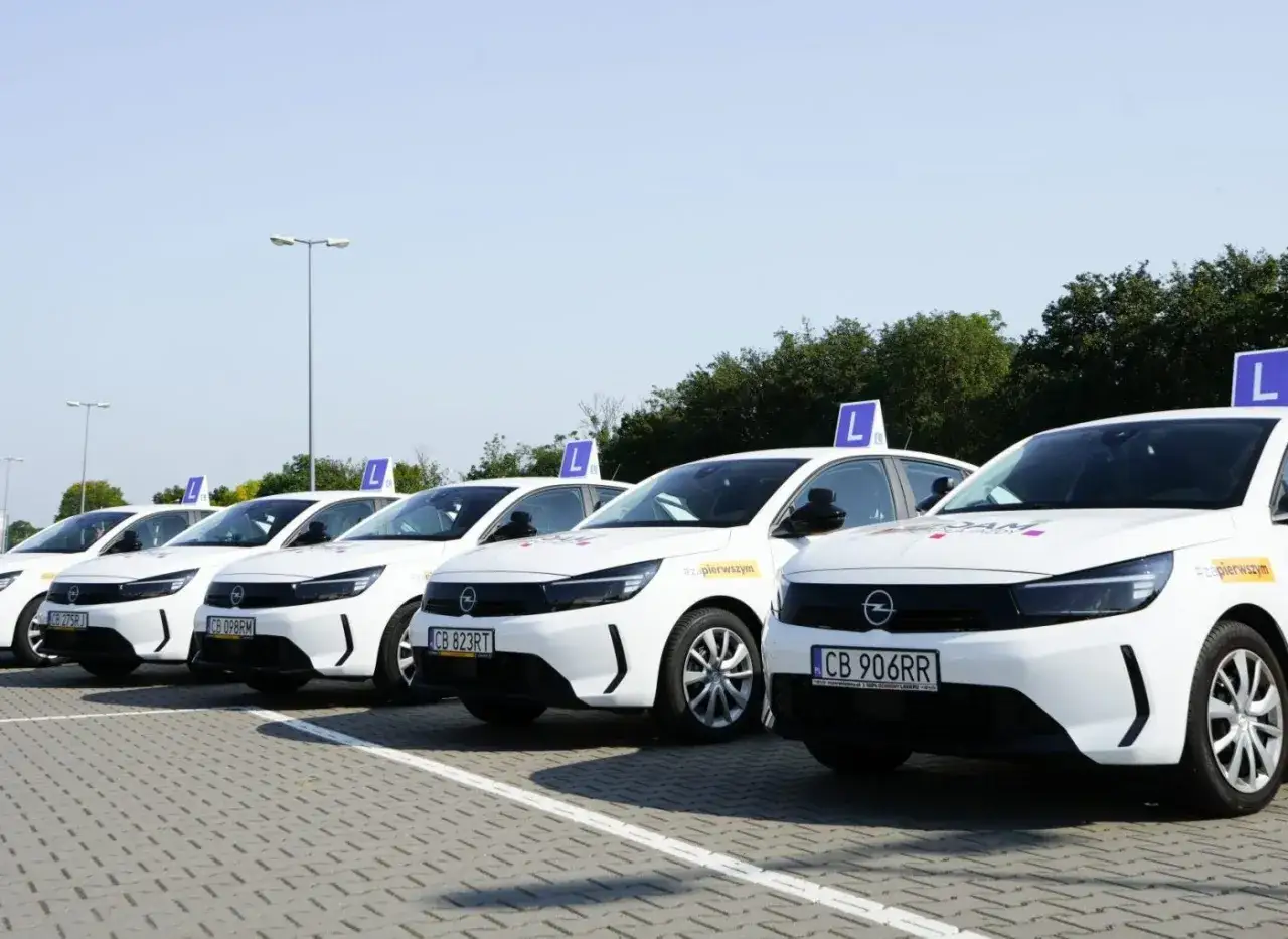 Rząd białych samochodów z literą 