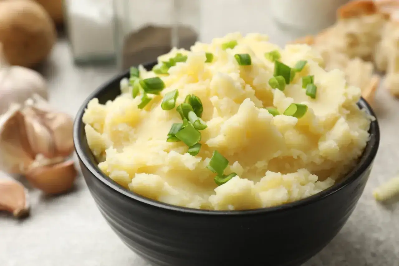 Puszyste puree ziemniaczane bez mleka, posypane szczypiorkiem. Idealne, gdy chcesz wiedzieć, jak zrobić puree ziemniaczane bez mleka.
