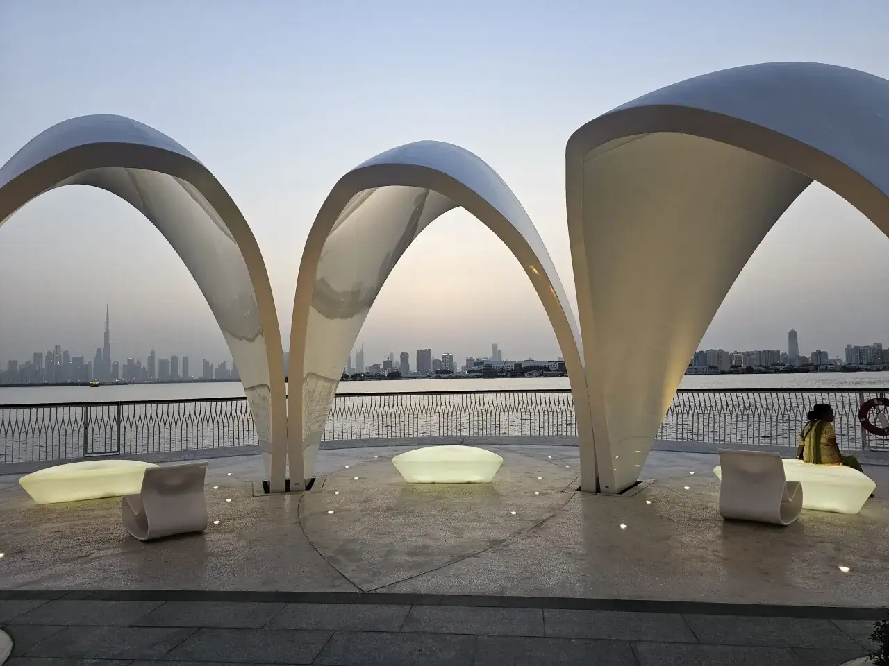 Nowoczesna architektura nad wodą w Dubaju, z widokiem na panoramę miasta. Odpowiedź na pytanie: czy w Dubaju jest bezpiecznie? Tak, można tu spokojnie spacerować.