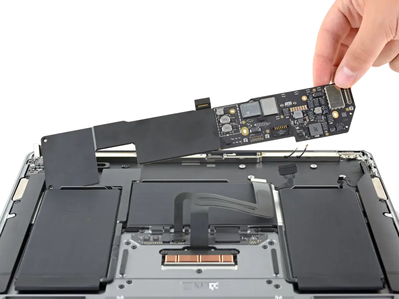 Dłoń wyjmuje płytę główną z wnętrza laptopa, który nie włącza się. Widać baterię i inne komponenty.