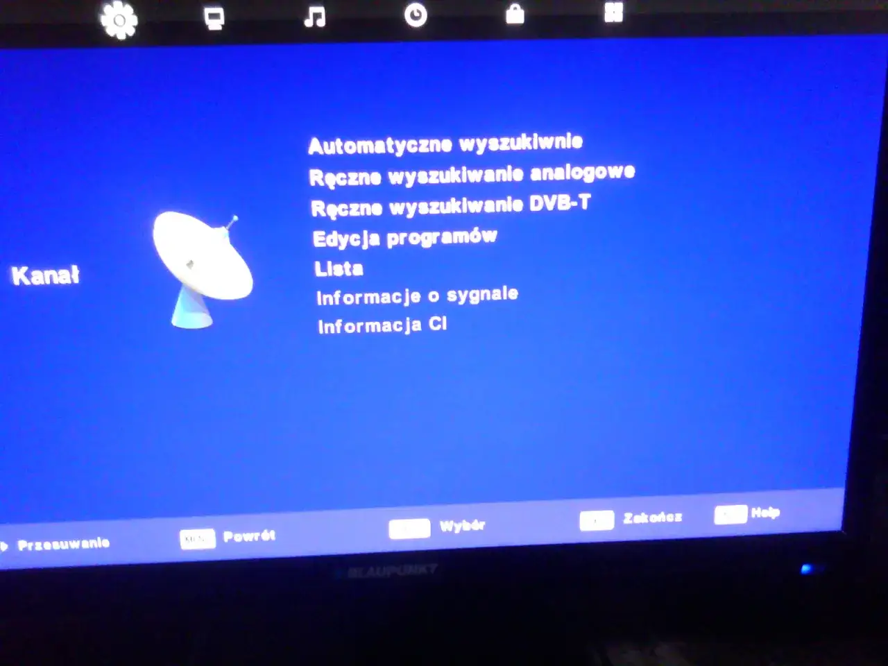 Menu telewizora z opcjami jak wyszukać kanały: automatyczne, ręczne analogowe i DVB-T. Widoczna antena satelitarna.