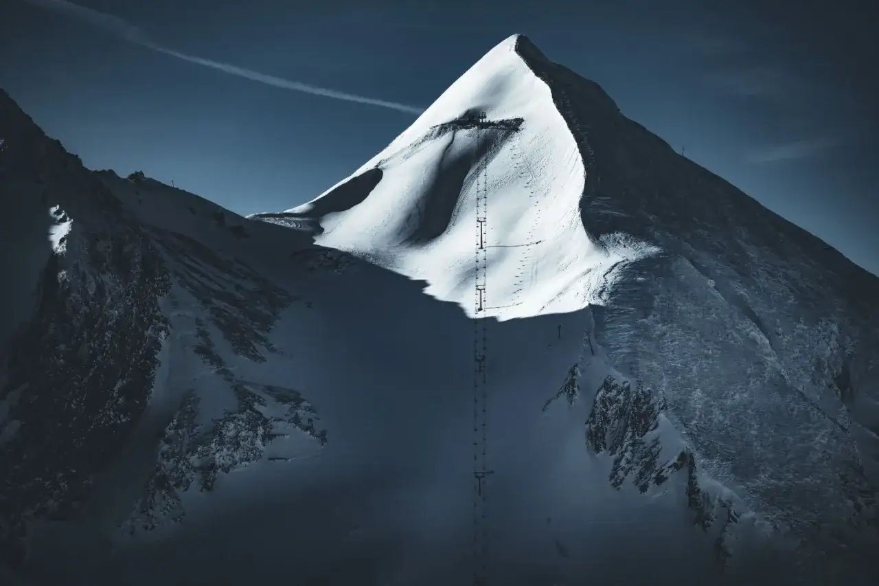 Ośnieżony szczyt z wyciągiem narciarskim, sugerujący najbardziej strome trasy narciarskie.