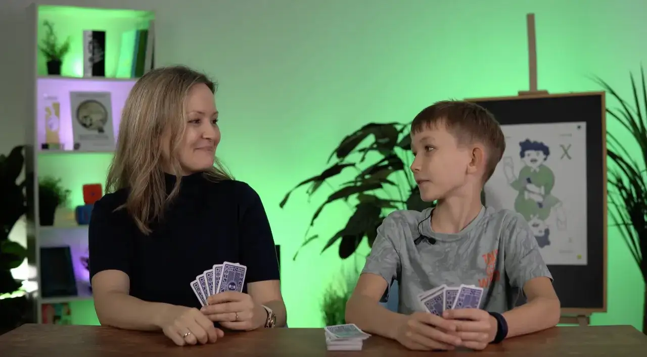 Mama i syn grają w karty, ucząc się, jak wytłumaczyć dziecku ułamki.