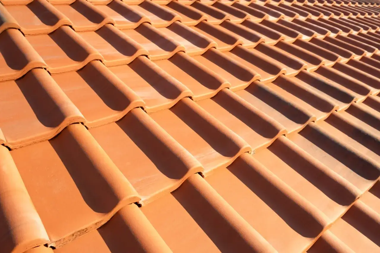 Zbliżenie na dachówkę ceramiczną w słońcu. Zastanawiasz się, ile dachówek na m2?