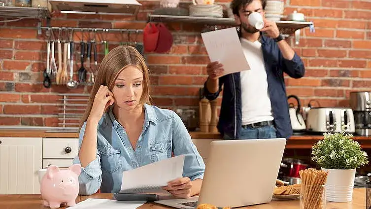 osoba planująca domowy budżet przy biurku
