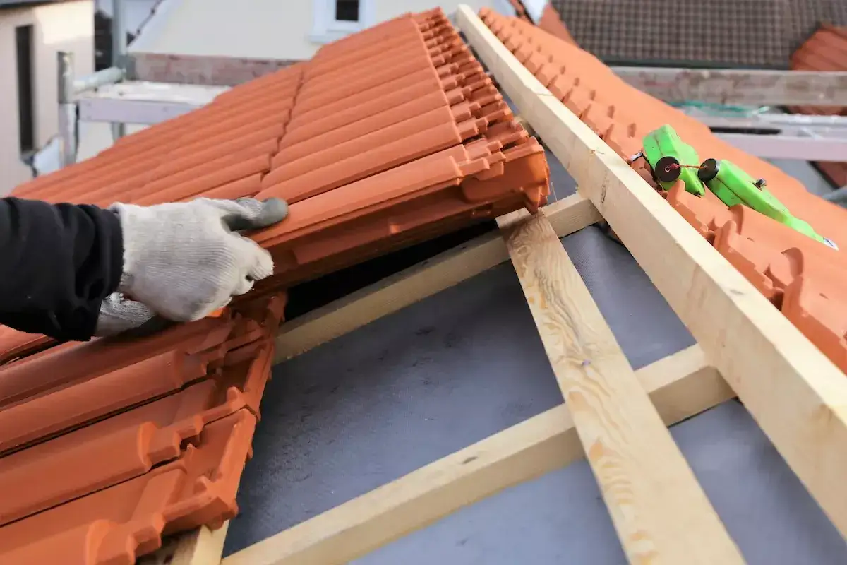 Dachówka ceramiczna układana na dachu. Zastanawiasz się, ile waży paleta dachówki ceramicznej?