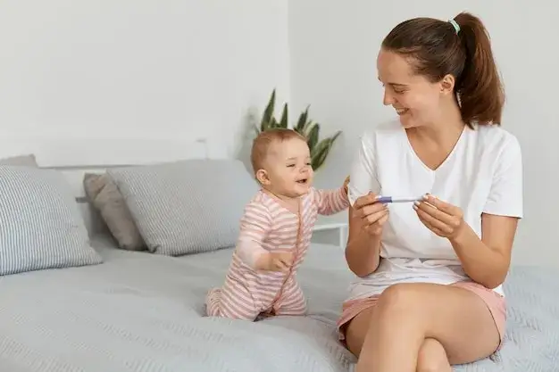 Kobieta z pozytywnym testem ciążowym i uśmiechem