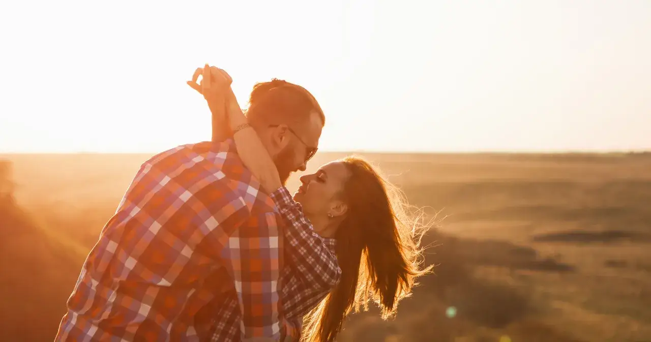 Para zakochanych w blasku zachodzącego słońca. Ich spojrzenia mówią wszystko, co oznacza słowo love.