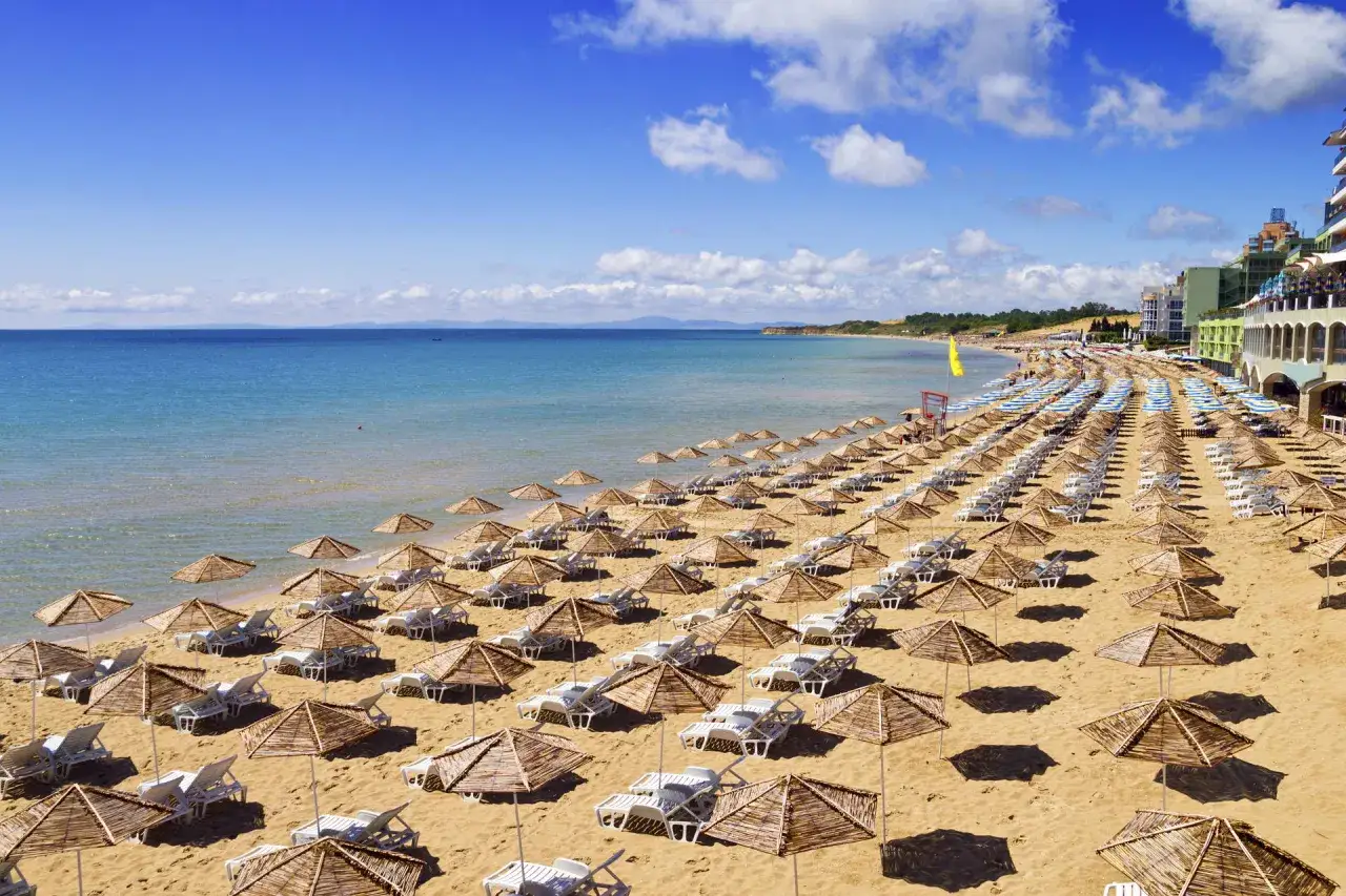 Plaża w Bułgarii z rzędami leżak&oacute;w i parasoli. Ceny w Bułgarii są atrakcyjne, co widać po liczbie turyst&oacute;w.