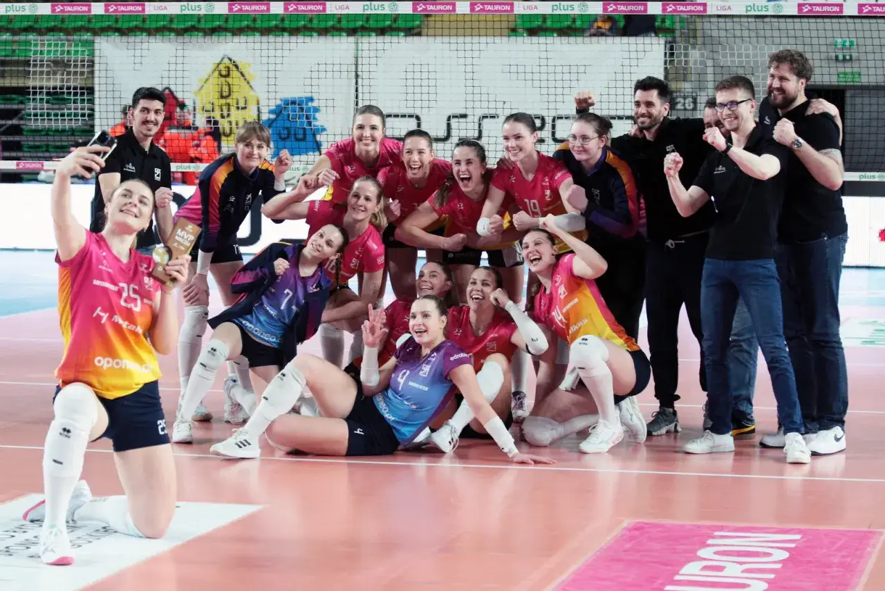 Drużyna siatkarska Pałac Bydgoszcz świętuje zwycięstwo. Zawodniczki w różowych strojach pozują do zdjęcia z pucharem MVP.